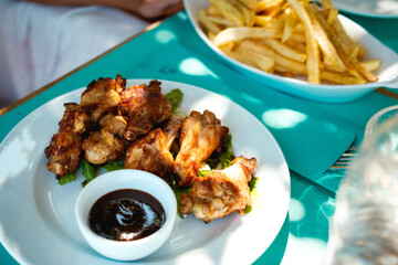 Chicken Wings und Pommes frites am Tisch