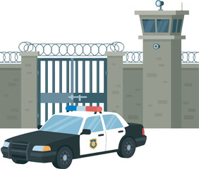 A police car parked in front of a prison's gate and watchtower.
