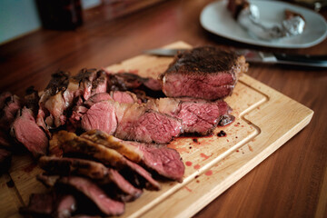 Aufgeschnittenes Tomahawk Steak Medium Rare auf Holzbrett