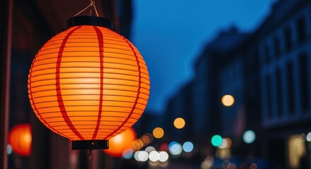 Obraz premium Vibrant orange lantern illuminating a dark evening street with city lights bokeh