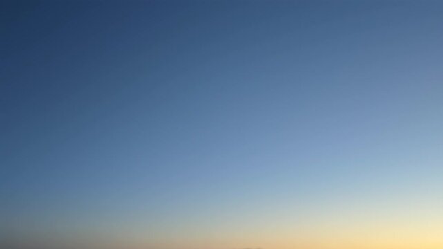 Deep blue pre-sunrise sky with golden horizon and early morning light for calm background