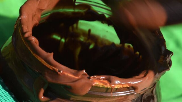Chocolate cream, on a spoon, taken from a jar, close-up.