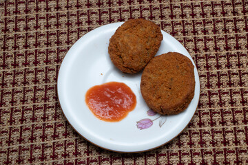 Golden Chicken Nuggets Cutlets with a dollop of zesty red sauce, offering a delightful taste of comfort and convenience for any occasion.