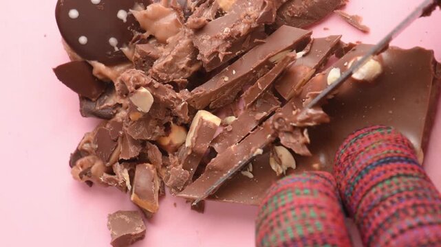 Chocolate with nuts cut with a knife, small pieces, close-up.