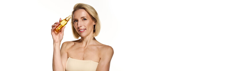 Fototapeta premium Blonde woman promoting skincare with a golden serum for healthy, radiant skin