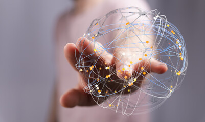 Close-up of a hand holding a glowing sphere representing global connections, business and...