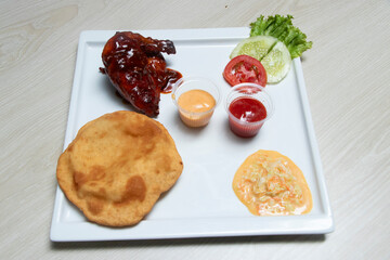 BBQ chicken quarter paired with a soft fried bread, creamy coleslaw, and savory dipping sauces. An irresistible combination for any appetite.