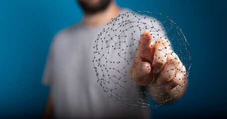 Close up of person's hand pointing at a sphere of connected dots, representing a global network, concept of technology, communication and data.