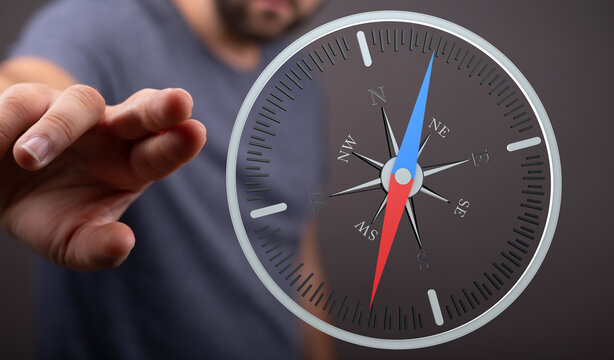 Close up shot of a person's hand interacting with a compass. Concept for travel, adventure, and new beginnings. Finding direction. Focus on deci