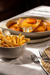The “Francesinha Especial" traditional from northern Portugal, consists of layers of bread, assorted meats, and melted cheese, served with a hot and slightly spicy sauce.
