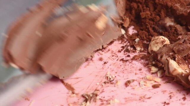 Milk chocolate with nuts cut with a knife, small pieces, close-up.
