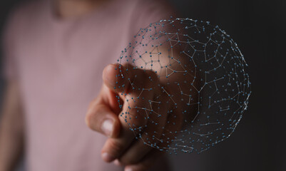 A person's finger pointing toward a digital network sphere, representing global connection,...