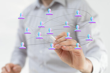 Visual of a person's hand drawing a network with abstract human icons, representing connection, communication, and collaboration. Suitable for b