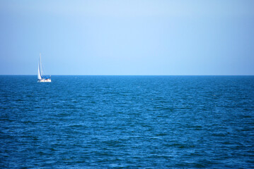 Ein einsames Segelboot treibt auf der blauen Adria.