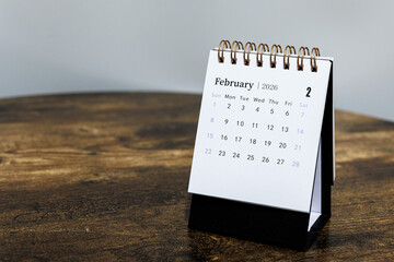 February 2026 monthly calendar page on a wooden desk, minimal design planner representing time management and organization at workplace