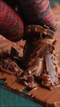 Close-up of crushing and squeezing a chocolate candy with cream filling.