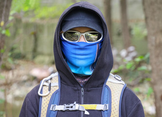 Portrait of a young girl with a face covered by glasses and a baloclava. Unrecognizable. Revolutionary.