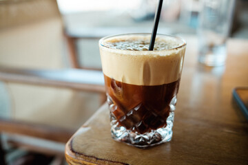 Freddo Espresso mit Strohhalm auf Holztisch