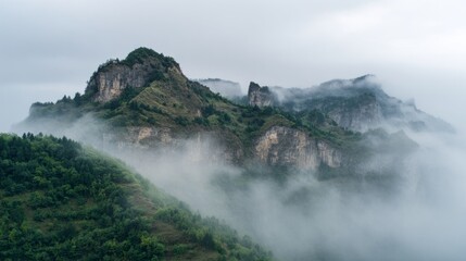 Obraz premium Province mountains covered in mist rise above dense green trees.