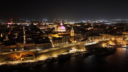 Aerial night view of illuminated city with cathedral and waterfront
