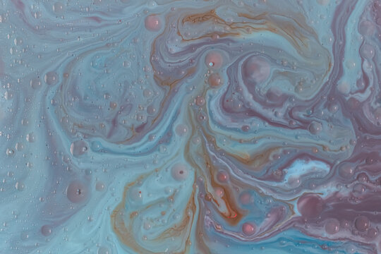 Macro shot of fluid art with soft blue, gray, and lilac tones. Gentle swirls and bubbles create a calm, dreamy texture ideal for minimalist or spa-related design themes