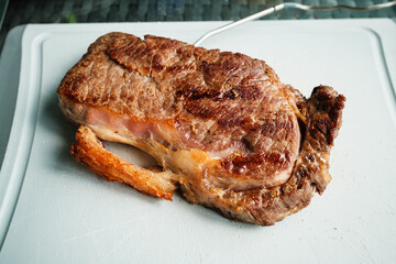 Gegrilltes Rumpsteak auf Kunststoffbrett mit Temperaturf&uuml;hler
