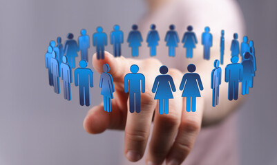 A hand pointing at a circle of human figures. Concept of community, teamwork, diversity and global...