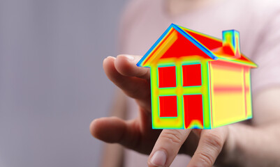 Conceptual image of a hand holding an abstract house, symbolizing home ownership, dreams, and...