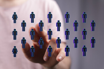 Hand pressing human icons representing social network and global connection. Illustrating online communities, teamwork, and digital interaction