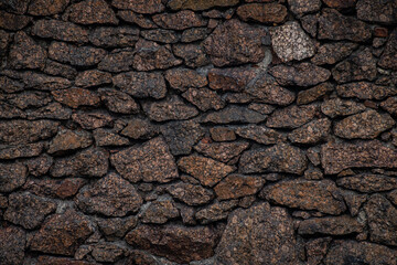 Textured granite boulder masonry with deep, dark joints. Natural stone texture © Alexei Vinnikov