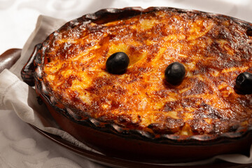 The "Bacalhau com Natas", a traditional Portuguese oven-baked codfish dish made with flaked cod, potatoes and onions, baked until golden and creamy, and often topped with black olives.
