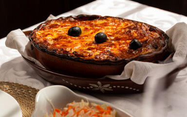 The "Bacalhau com Natas", a traditional Portuguese oven-baked codfish dish made with flaked cod, potatoes and onions, baked until golden and creamy, and often topped with black olives.
