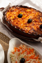 The "Bacalhau com Natas", a traditional Portuguese oven-baked codfish dish made with flaked cod, potatoes and onions, baked until golden and creamy, and often topped with black olives.