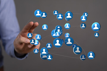 Hand reaching towards a network of connected people icons. Represents social connection, communication, and digital networking in a global conce