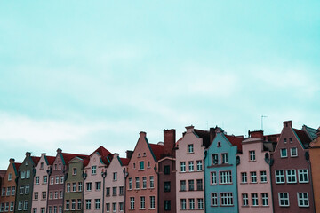 Colorful historic houses in Gdańsk, Poland, with pastel façades and decorative gables. The bright daylight creates a nostalgic yet modern retro mood, emphasizing architectural patterns and symmetry.