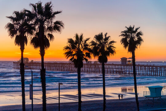 Oceanside Pier  is silhouetted against a sunset on a colorful California night.