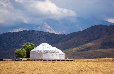 Yurt. National ancient dwelling of the peoples of Kazakhstan and Asian countries. National dwelling. Yurts against the backdrop of green meadows and highlands. Yurt camp for tourists in the mountains.
