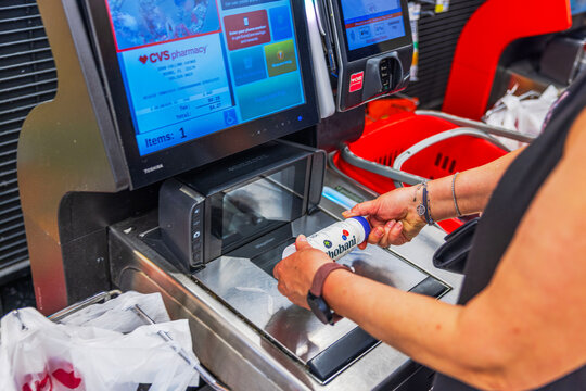Close up view of woman scanning Chobani yogurt drink at CVC self checkout register in supermarket. Miami Beach. USA. 