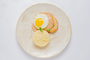 A tasty breakfast with a sunny-side-up egg, chicken patty, and creamy mashed potatoes