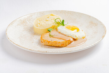 A delicious breakfast features tender chicken, creamy mashed potatoes, and a sunny egg