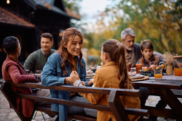 Happy mother talking to her daughter during family Thanksgiving gathering.