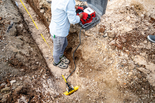 Electrofusion welding device. Cables from this device join a coupling on a yellow polyethylene (PE) natural gas distribution pipe in the trench to the main pipeline using electrofusion welding.