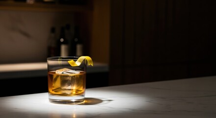 Cocktail with lemon twist and large ice cube on marble bar counter in dim lighting. Spirit drink for celebration, party, or relaxing evening.