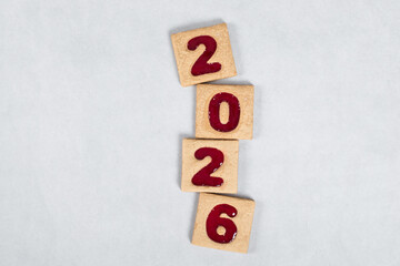 New Year 2026. Square cookies with red marmalade filling in the shape of the numbers 2026. White background. Top view