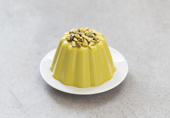 Pistachio Cream pudding. On a plate. Light gray background	