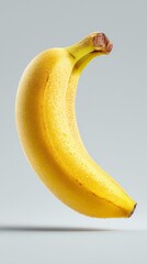 Fresh and vibrant yellow banana floating in the air. The banana is perfectly ripe, with a smooth peel and a slight curve