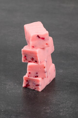 Raspberry candy with pieces of freeze-dried raspberries. Dark background. Close-up