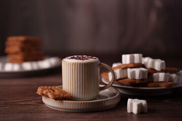 cozy scene featuring a ceramic mug with creamy hot beverage garnished with chocolate, accompanied by stacked cookies and marshmallows on rustic wooden table, minimalistic, indulgent, satisfying