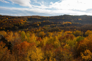 Fototapeta premium Autumn Landscape with Vibrant Forest and Rocky Hills