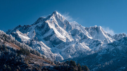 Obraz premium Snow-covered mountain peaks under bright blue sky in winter